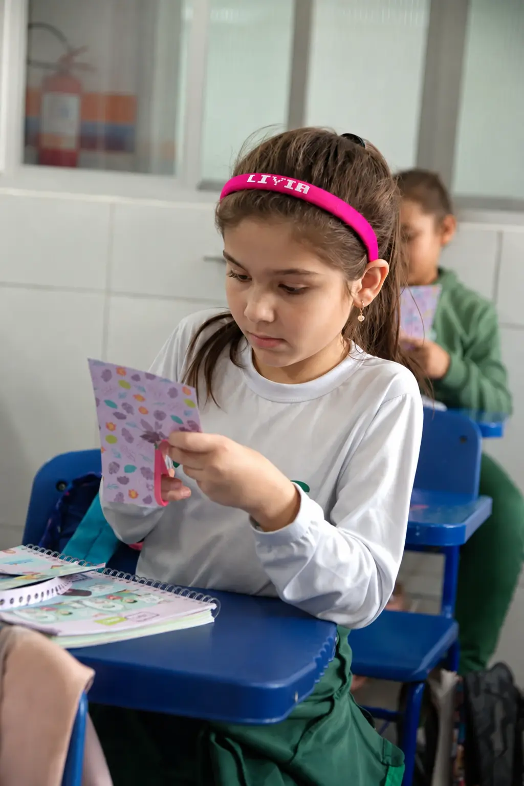 Educadora acompanhando alunos em atividade no Colégio Bliss