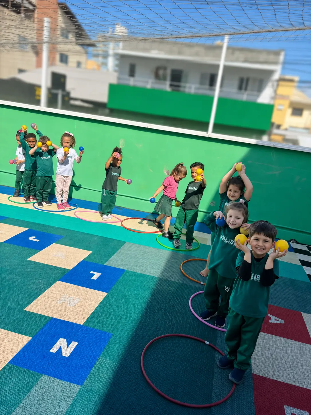 Crianças da Educação Infantil Bliss em uma atividade de movimento ao ar livre