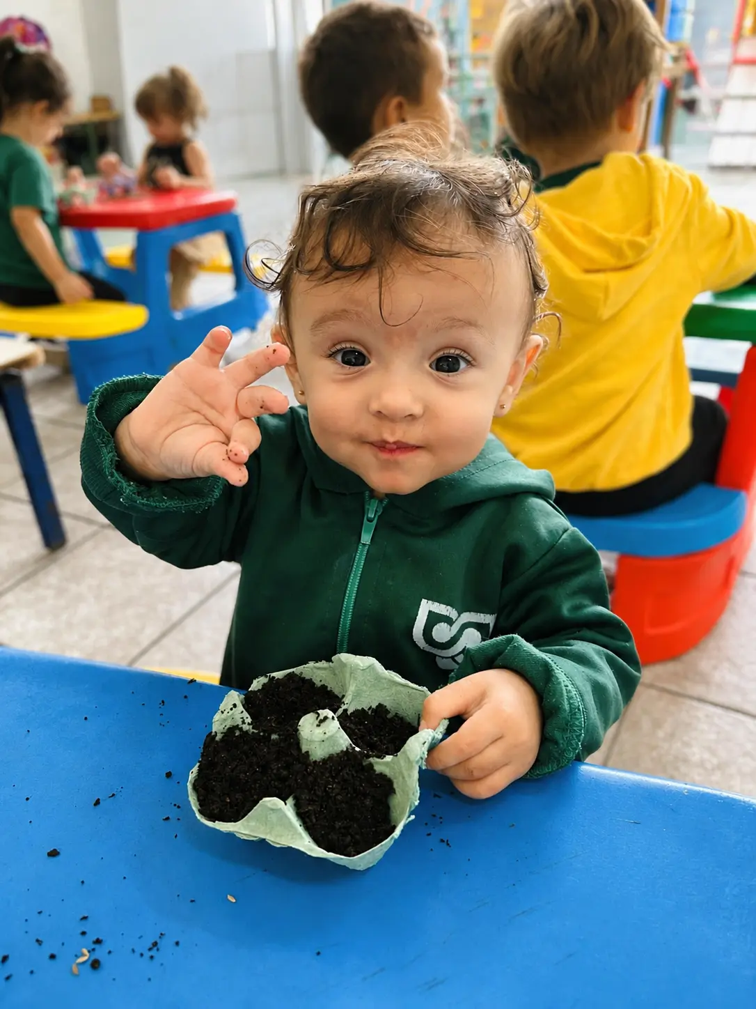 Criança da Educação Infantil Bliss participando de uma experiência com plantio